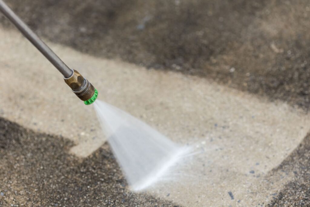Power washer cleaning sidewalk in Smyrna commercial area